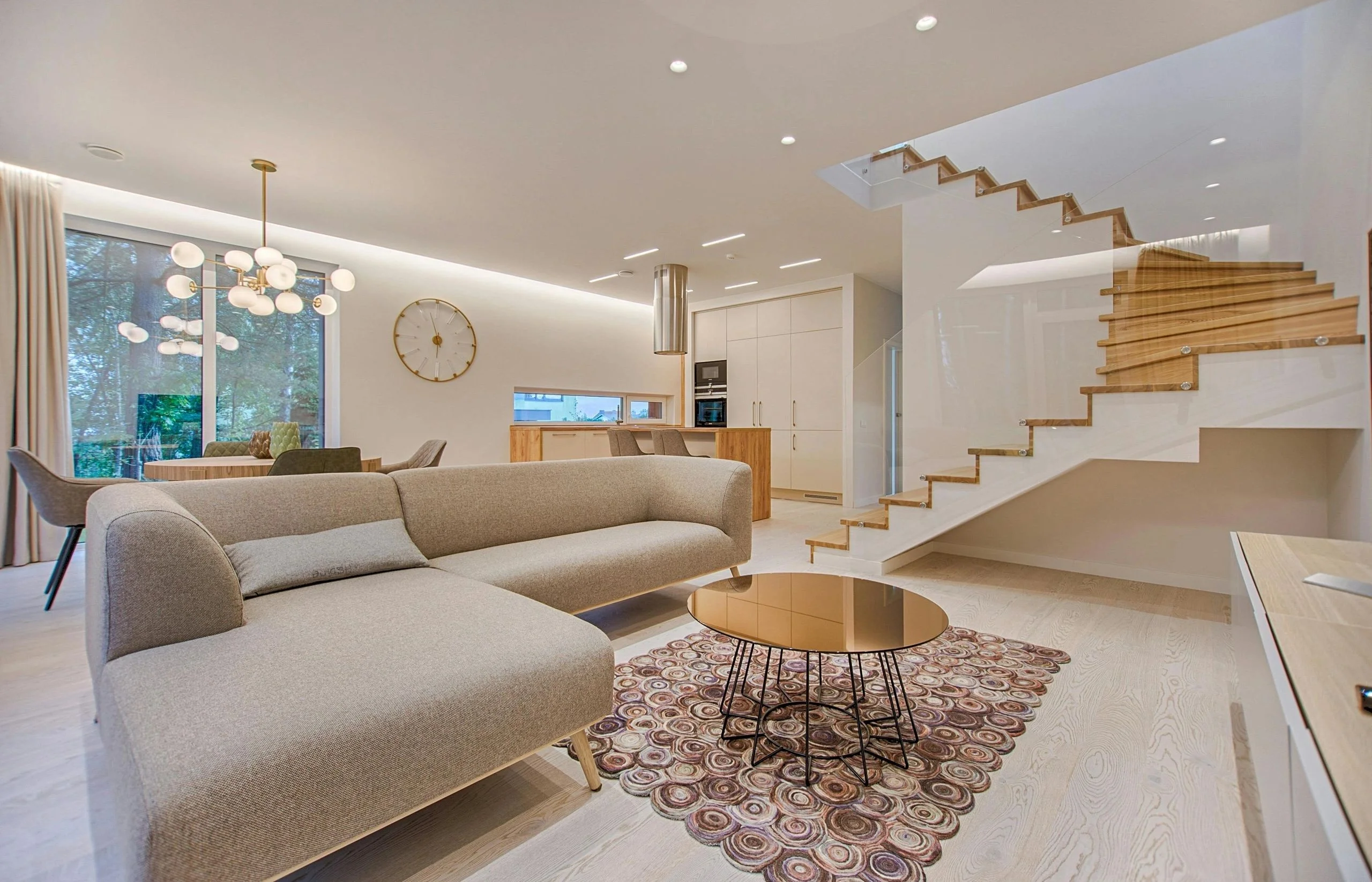 Luxury living room with refined furnishings, custom finishes, large windows, and a bright open interior.